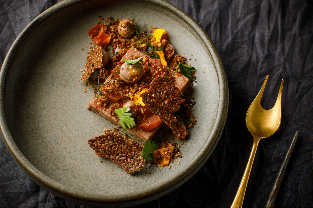 A ceramic plate containing an intricately garnished meal