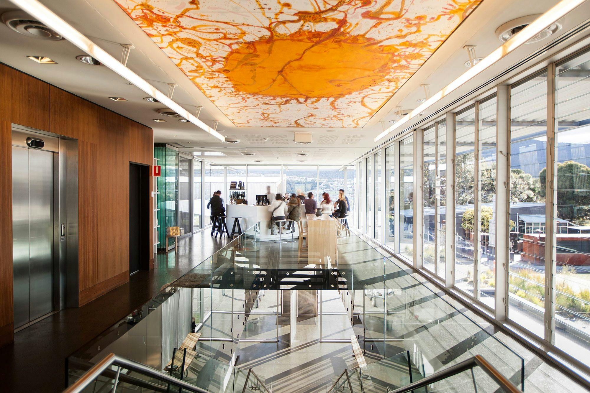 A room with floor to ceiling glass and people undertaking a tasting under Joh Olsen's The Source