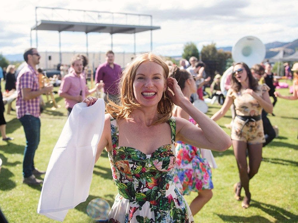 Kirsha smiling front on to the camera. Standing on the Mona lawns in a floral sun dress.