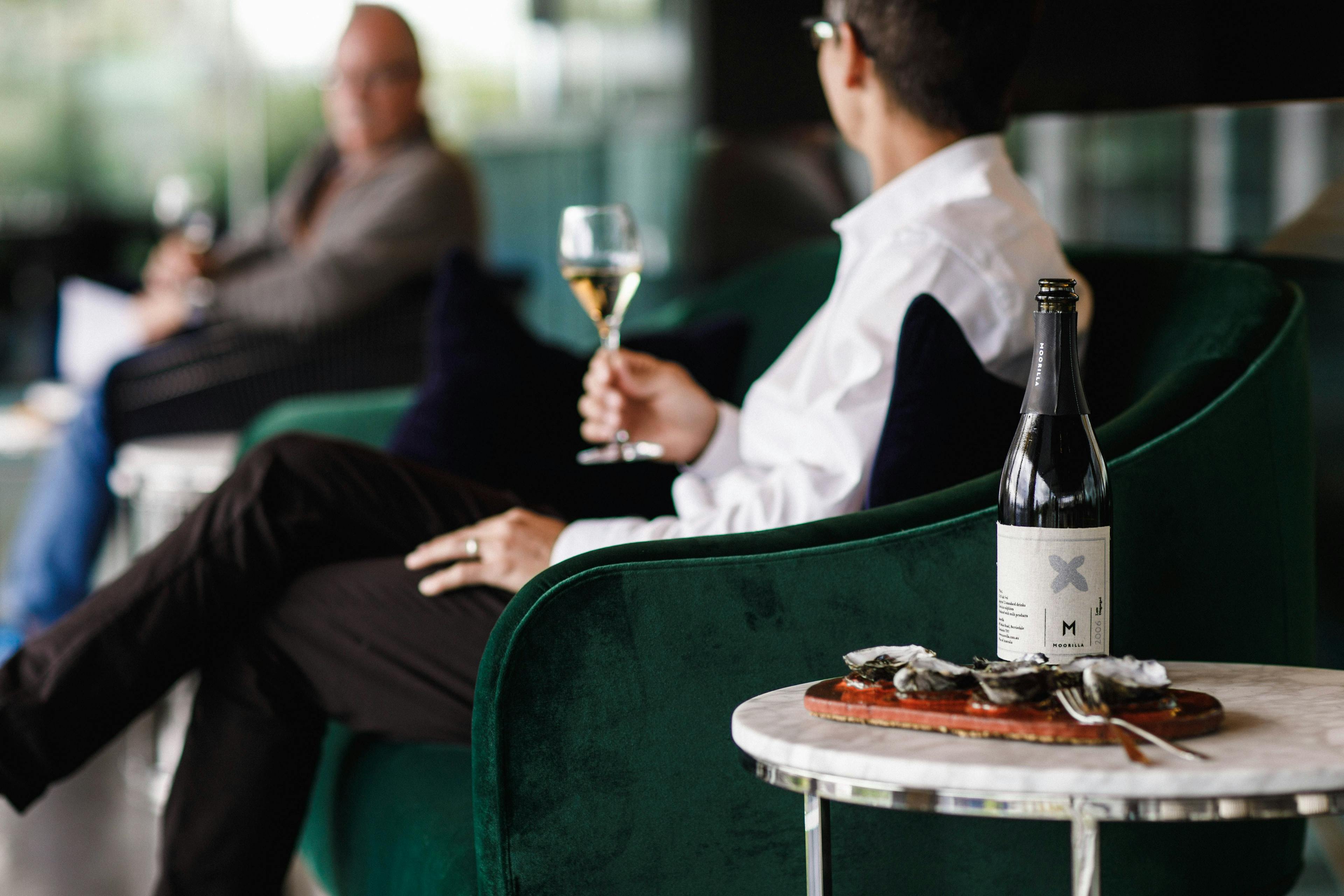 two men drinking a Moorilla white wine with a side of oysters