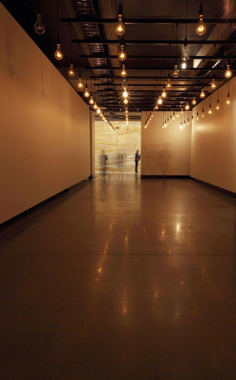 Light globes suspended in an empty and warmly lit room.